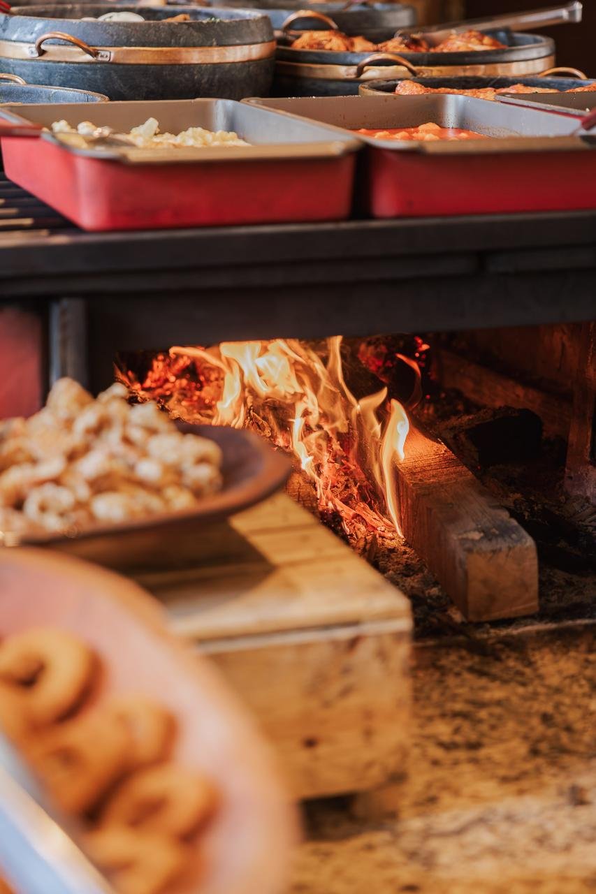 Pães e quitutes caseiros assando no forno a lenha